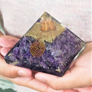 May include: Amethyst crystal pyramid with a copper wire spiral and gold glitter. The pyramid is approximately 3 inches tall.