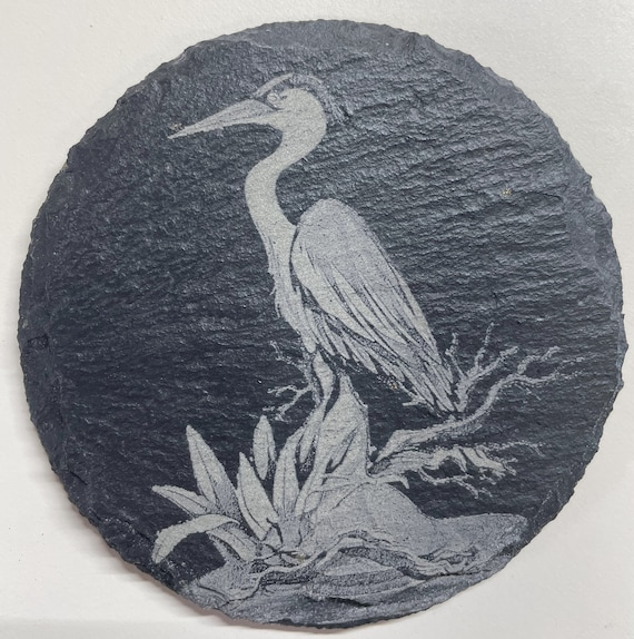 Slate coasters 4” round engraved with Heron.  Also available in 4” square. Custom designs available as well as design services.