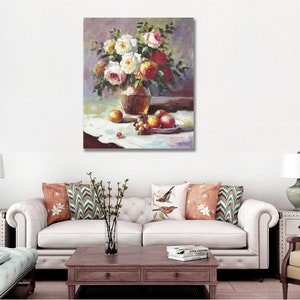 May include: A still life painting of a bouquet of white and red roses in a brown vase, with grapes and apples on a white tablecloth.