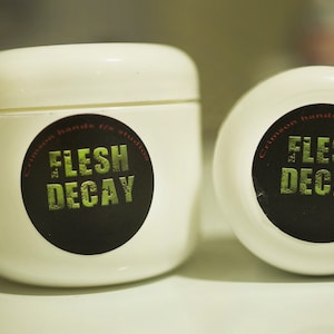 May include: Two white jars with black labels that say "Crimson Hands Studio Flesh Decay".