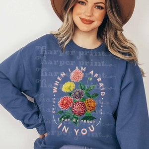 May include: A blue sweatshirt with a floral design and the text "When I am afraid I put my trust in you" with the scripture reference "Psalm 56:3".
