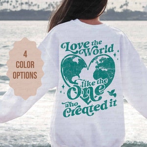May include: White sweatshirt with a teal green heart design that says "Love the World like the One who Created it".