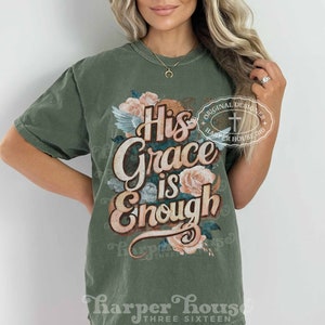May include: A green t-shirt with a floral design and the text "His Grace is Enough" in a vintage style font. The shirt also features a small cross and the text "Original Designer Harper House Three Sixteen".