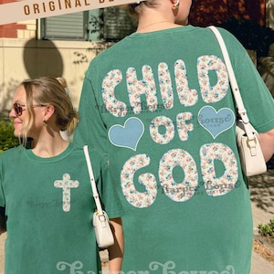 Könnte beinhalten: Zwei grüne T-Shirts mit dem Text "CHILD OF GOD" in floralem Druck auf dem Rücken. Ein Shirt hat ein florales Kreuz auf der Vorderseite. Der Markenname "Harper House THREE SIXTEEN" ist am unteren Rand der Shirts aufgedruckt. Beide Shirts werden von Personen getragen.