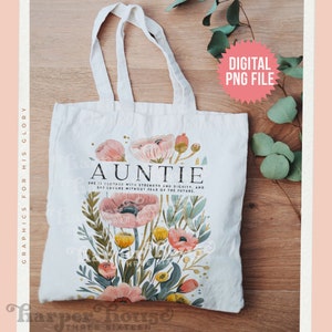 Puede incluir: Una bolsa de tela blanca con un diseño floral y el texto "Auntie" en letras doradas. La cita "Ella está vestida con fuerza y dignidad, y se ríe sin miedo al futuro." está impresa debajo del diseño floral.