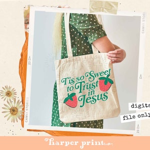 May include: A white tote bag with a green and red graphic that says "Tis so Sweet to Trust in Jesus". The graphic features a strawberry with a green stem and leaves.