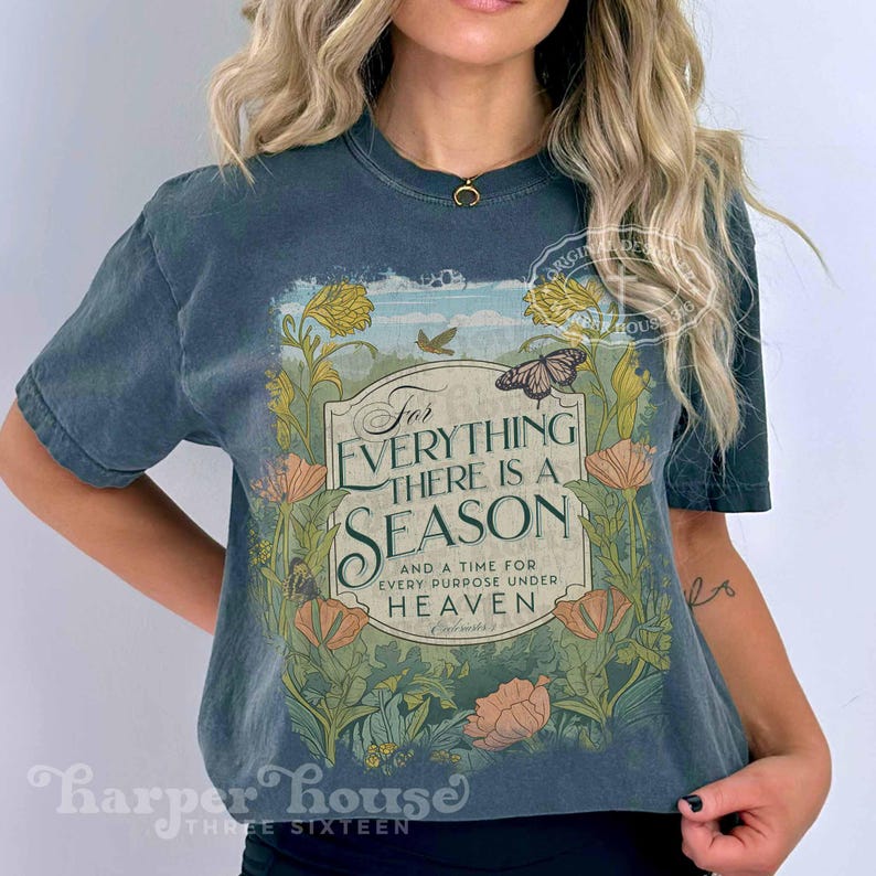 May include: A dark blue t-shirt with a vintage floral design and the text "For Everything There Is A Season And A Time For Every Purpose Under Heaven".
