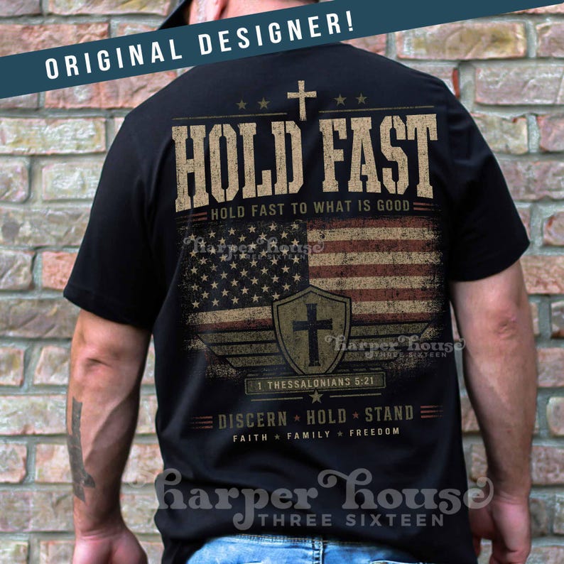 May include: Black t-shirt with a distressed American flag design and the words "HOLD FAST" and "DISCERN HOLD STAND". The shirt also features a cross and the text "1 THESSALONIANS 5:21".