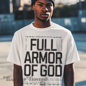 Peut inclure: T-shirt blanc avec un texte noir qui dit "Stand Firm, Therefore Put On The Full Armor Of God, Pray Always". Le texte est entour&eacute; de barbel&eacute;s et les mots "Six:13" et "Three Sixteen" sont &eacute;galement inclus.