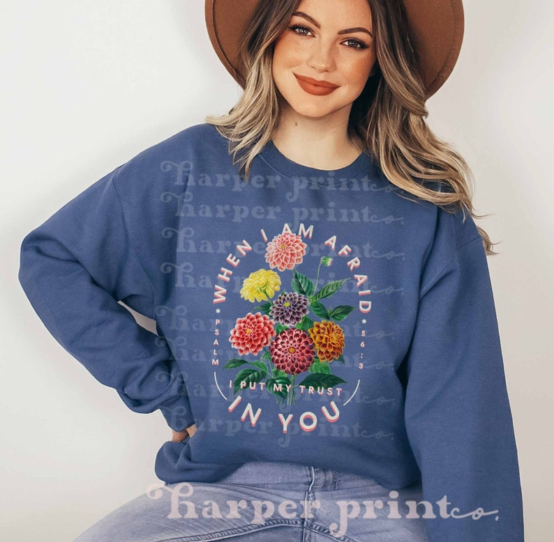 May include: A blue sweatshirt with a floral design and the text "When I am afraid I put my trust in you" with the scripture reference "Psalm 56:3".