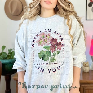 May include: A gray sweatshirt with a floral design and the text "When I am afraid I put my trust in you" and "Psalm 56:3".