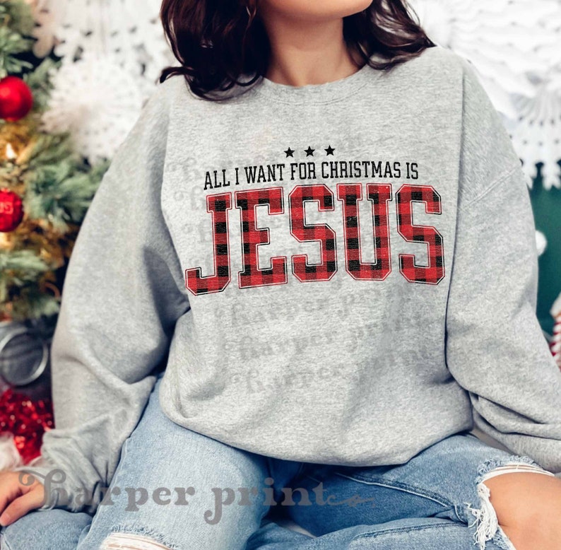 May include: Gray sweatshirt with a red and black buffalo plaid design. The text "All I want for Christmas is Jesus" is printed on the front of the sweatshirt.