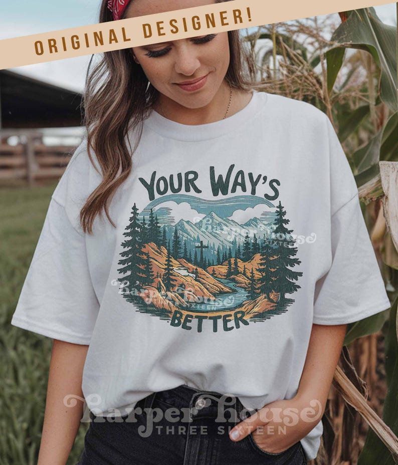 May include: White t-shirt with a nature-themed graphic. The design features a mountain range, trees, and a river, with the text "YOUR WAY'S BETTER". The shirt also has the text "ORIGINAL DESIGNER!" at the top.