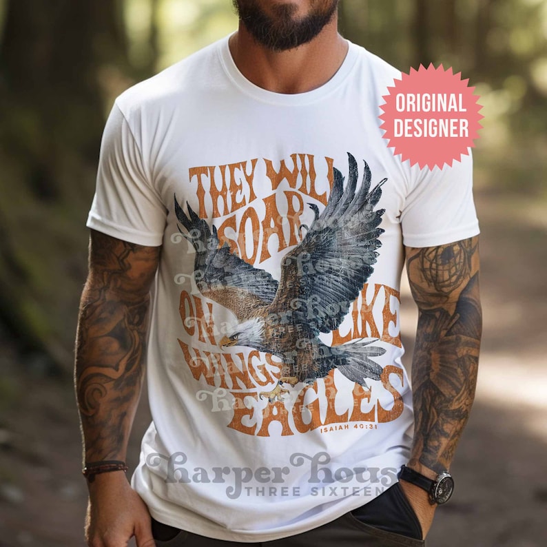May include: White t-shirt with a vintage-style graphic of an eagle in flight. The graphic features the text "They Will Soar On Wings Like Eagles" and the scripture reference "Isaiah 40:31".