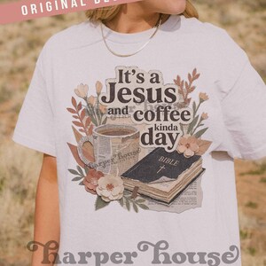 May include: White t-shirt with a graphic design featuring the text "It's a Jesus and coffee kinda day." The design includes a coffee cup, a Bible, and floral accents. The shirt also has the text "Harper House THREE SIXTEEN."
