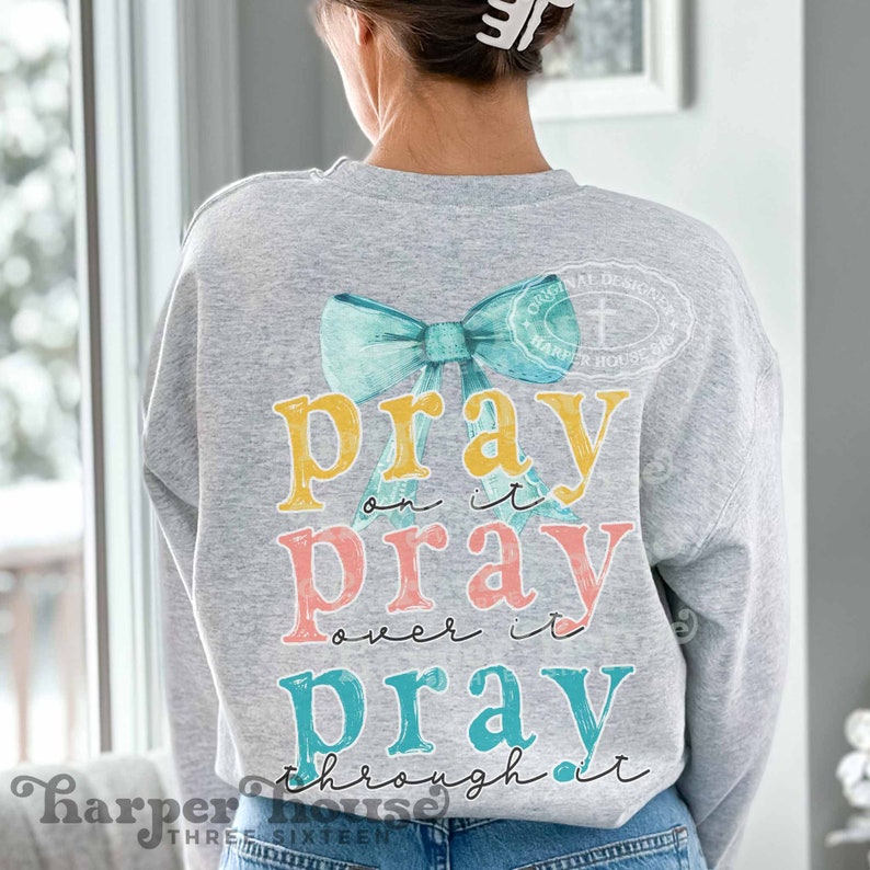 May include: A gray sweatshirt with a turquoise bow and the text "pray on it pray over it pray through it" in yellow, pink, and turquoise.