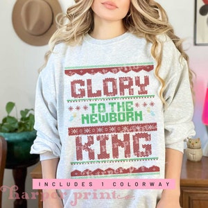 May include: A gray sweatshirt with a red and green Christmas-themed design that reads "Glory to the Newborn King".
