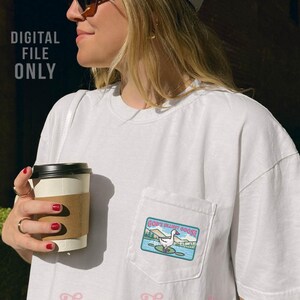 K&ouml;nnte beinhalten: Wei&szlig;es T-Shirt mit einer Tasche mit einem farbenfrohen Aufn&auml;her mit der Aufschrift "God's Silliest Goose" und einer Cartoon-Gans auf einer Seerose. Das Shirt hat auch den Text "DIGITAL FILE ONLY" und den Markennamen "Harper House Three Sixteen".