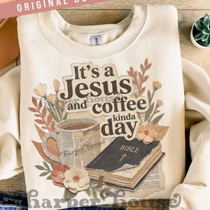 May include: Cream-colored sweatshirt with the text "It's a Jesus and coffee kinda day" and a graphic of a coffee cup, Bible, and floral accents. The words "ORIGINAL DESIGNER!" are printed at the top.