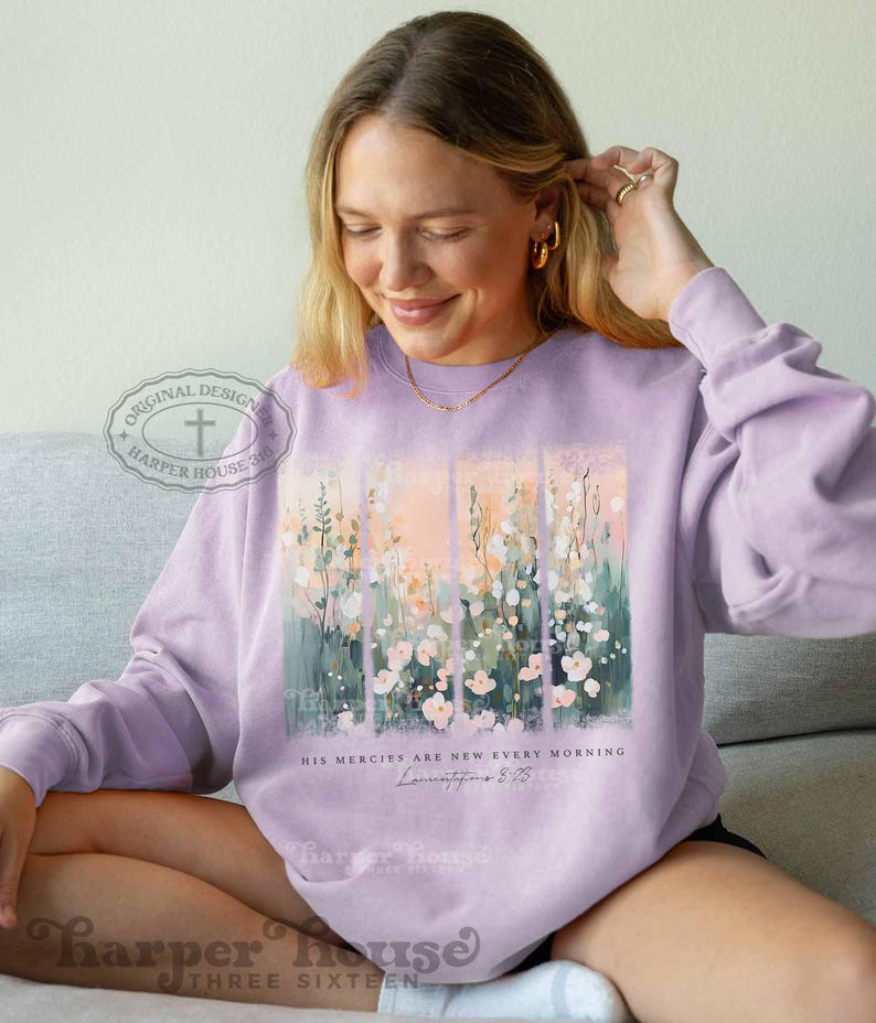 May include: A lavender sweatshirt with a floral design and the text "His mercies are new every morning" and a scripture reference. The sweatshirt has a cross and the text "Harper House 316" on the left sleeve.