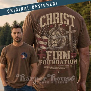 May include: Brown t-shirt featuring a lion, cross, and American flag design with the text "CHRIST IS MY FIRM FOUNDATION." The shirt also has a small emblem with a cross and American flag. The brand name "Harper House" is visible.