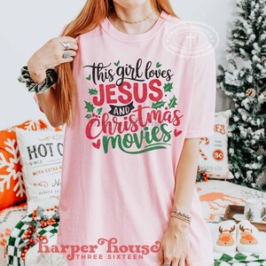 May include: Pink t-shirt with a green and red graphic that says "This girl loves Jesus and Christmas movies".