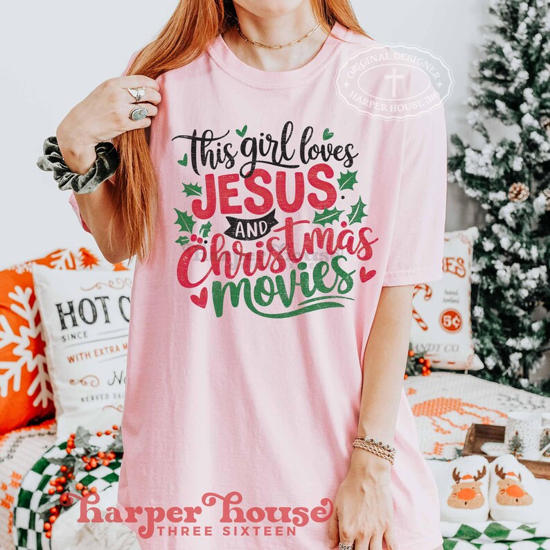 May include: Pink t-shirt with a green and red graphic that says "This girl loves Jesus and Christmas movies".