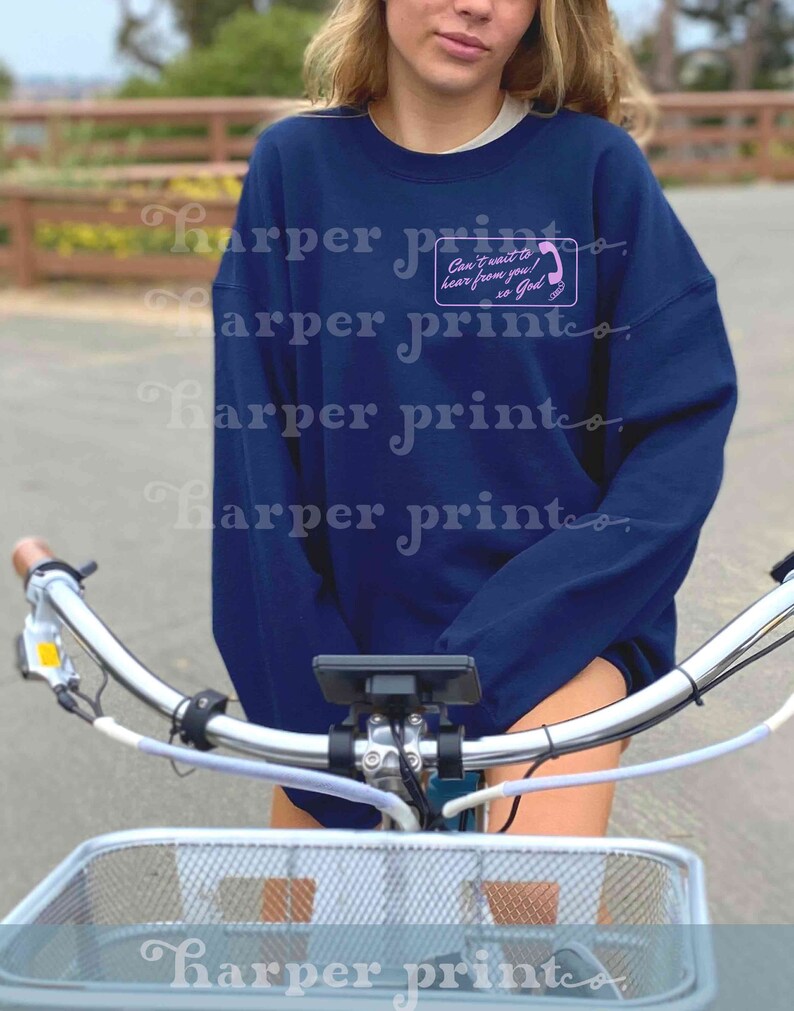 May include: A navy blue sweatshirt with a pink phone graphic and the text "Can't wait to hear from you! xo God".