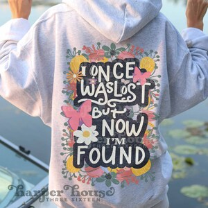 May include: A gray hoodie with a floral design and the text "I once was lost but now I'm found".