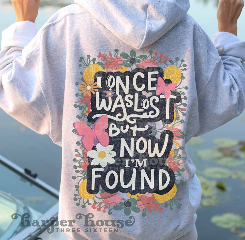 May include: A gray hoodie with a floral design and the text "I once was lost but now I'm found".