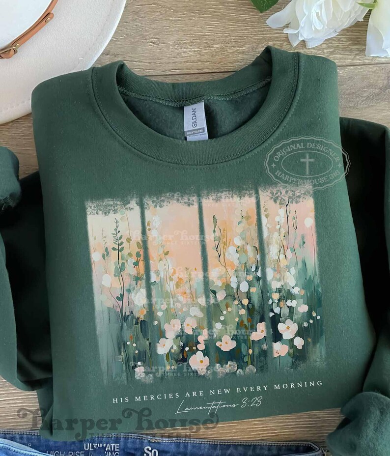 May include: A dark green sweatshirt with a floral design and the text "HIS MERCIES ARE NEW EVERY MORNING Lamentations 3:23".