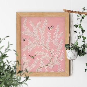 May include: A framed print of a pink and white floral design with birds and butterflies. The print is in a light wood frame.