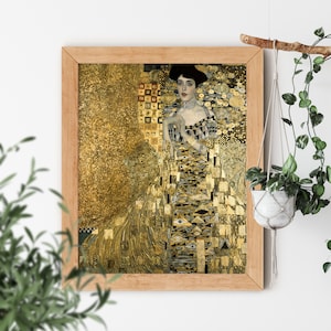 May include: A framed painting of a woman in a gold dress with a geometric pattern. The background is also gold with a geometric pattern. The woman is wearing a black hat and a necklace.