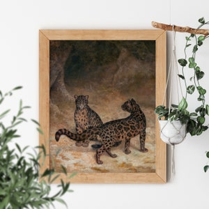 May include: A painting of two leopards in a cave setting. The leopards are brown and black with spots. The painting is framed in a light wood frame.