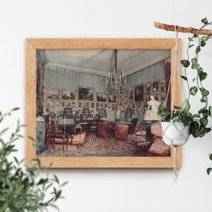 May include: A framed vintage photograph of a room with a chandelier, ornate furniture, and paintings on the walls. The room is decorated in a traditional style with a patterned rug on the floor.