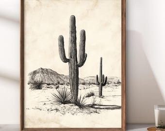 May include: A framed black and white print depicting a desert scene with saguaro cacti and other desert flora. The artwork has a vintage style, with a sepia-toned background and a wooden frame.
