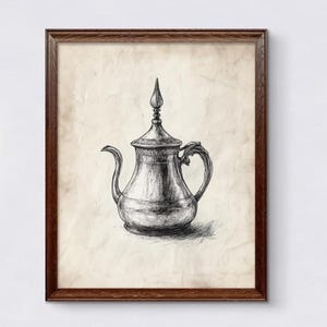 Puede incluir: Un dibujo en blanco y negro de una tetera de plata con una tapa y un pico decorativos. La tetera está enmarcada en un marco de madera marrón.