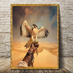 Puede incluir: Una pintura enmarcada en oro de un halcón posado en una mano enguantada. El halcón tiene plumas marrones y blancas y mira hacia un lado. El fondo es un paisaje desértico con dunas de arena.