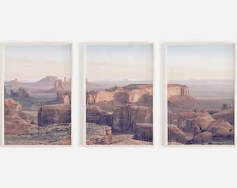 Puede incluir: Conjunto de tres láminas enmarcadas con paisajes de cañones desérticos. Las láminas muestran formaciones rocosas de color marrón rojizo bajo un cielo suave y pastel. La obra de arte evoca una sensación de inmensidad y belleza natural, ideal para la decoración del hogar.
