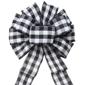 May include: A black and white checkered bow with long tails. The bow is tied in a classic style with the tails hanging down.