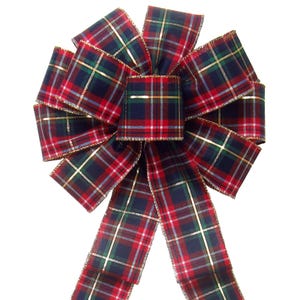 May include: A large, decorative plaid bow in red, navy, green, and gold. The bow features a classic tartan pattern with gold trim along the edges. Perfect for holiday decorations, this bow adds a festive touch to any gift or display.