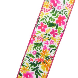 May include: White ribbon with a pink, yellow, and green floral print. The ribbon has a pink edge.