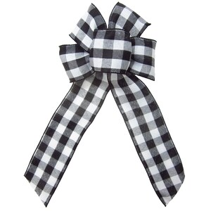 May include: A black and white checkered bow with a center loop. The bow is made of a soft, textured fabric.