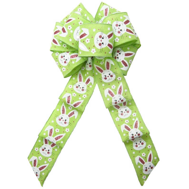 May include: A green and white ribbon bow with a repeating pattern of white bunnies with pink noses and white flowers. The bow is tied in a large, full loop.