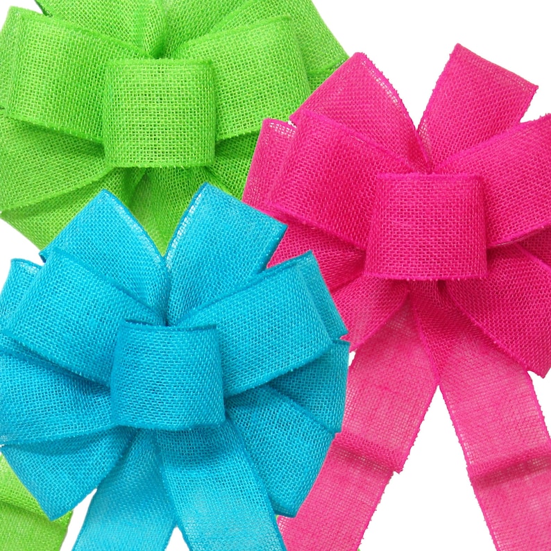 May include: Three burlap bows in bright colors: lime green, turquoise blue, and hot pink. The bows are tied with a simple knot and have a rustic, handmade look.
