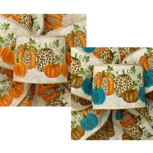 May include: A close-up of a fabric ribbon with a repeating pattern of orange and teal pumpkins with leopard print accents. The ribbon is on a beige background.