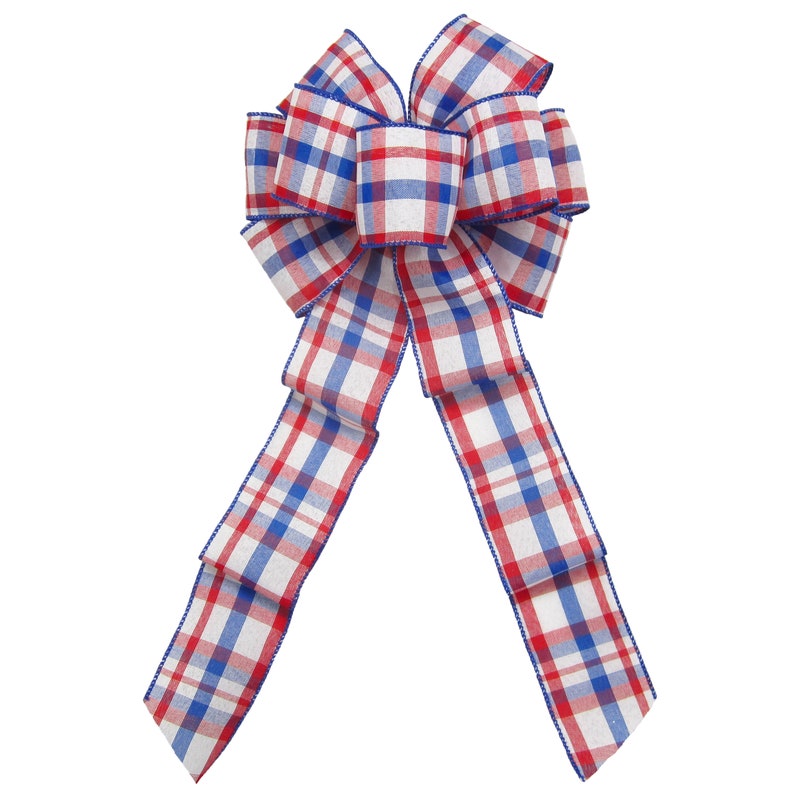 May include: A red, white and blue plaid bow with a wired edge. The bow is tied in a classic loop shape with two tails.