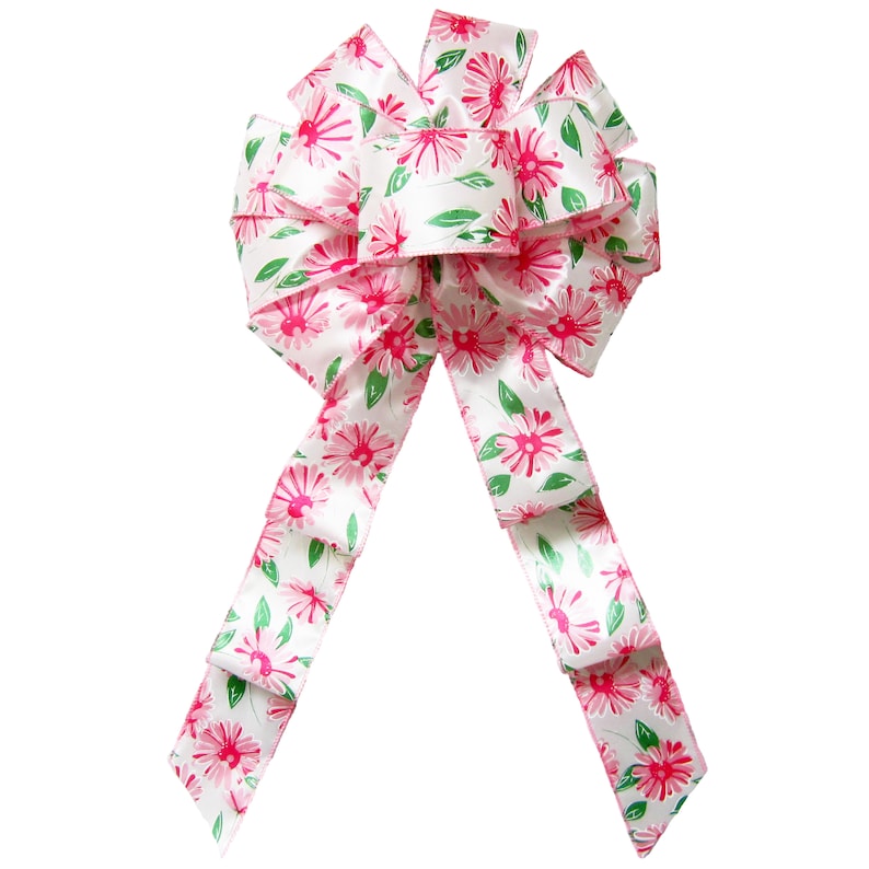 May include: A white satin bow with pink floral print. The bow has two long tails and is tied in a classic knot.