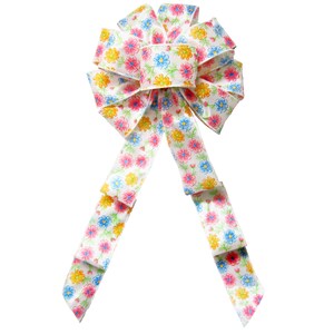 May include: A white satin bow with a floral print in pink, blue, and yellow. The bow is tied with two long tails.