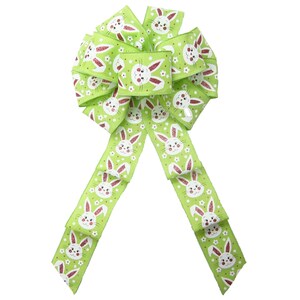 May include: A green and white ribbon bow with a bunny rabbit pattern. The bow is tied with a loop and tails.